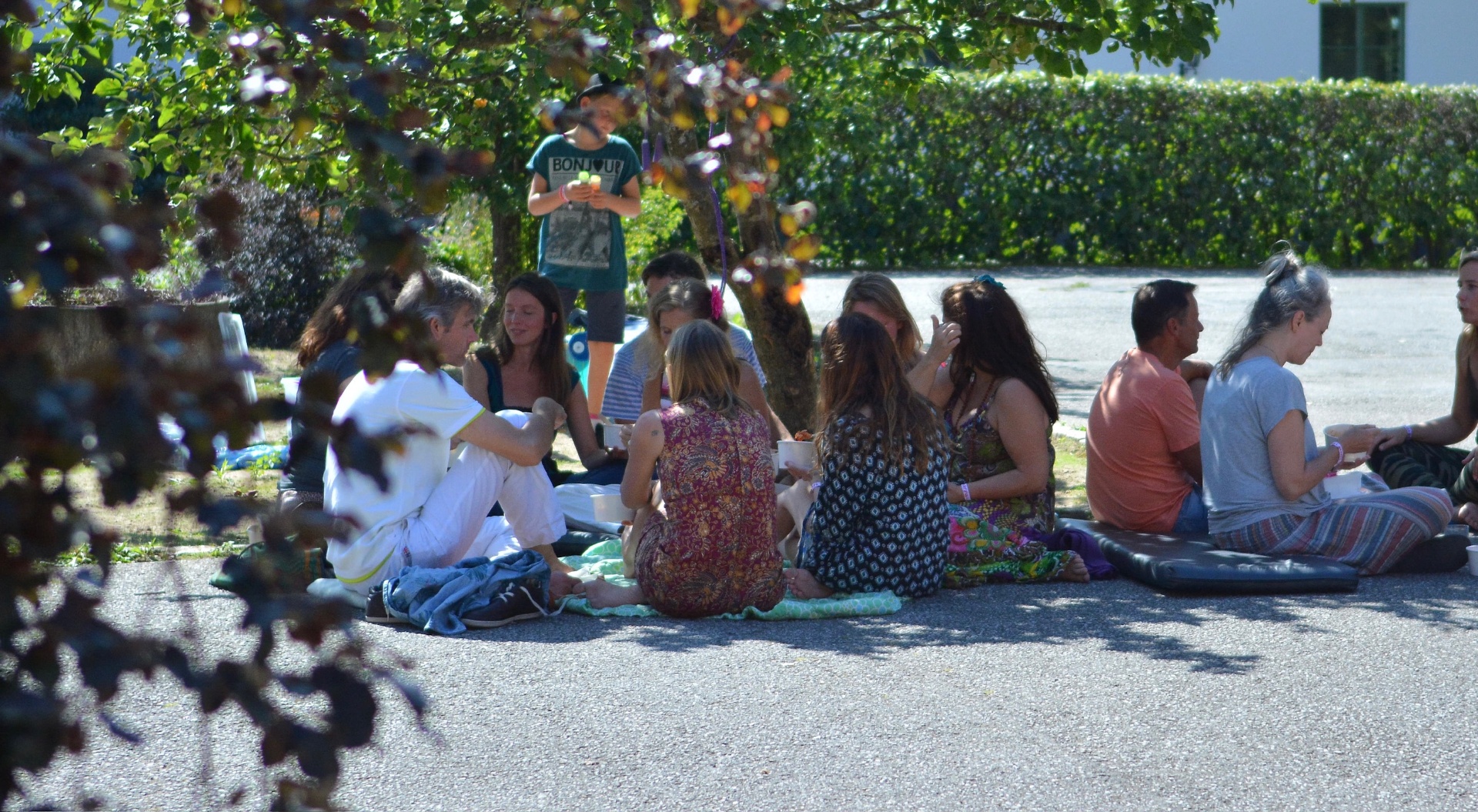People gathering and sharing a meal under the trees